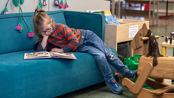 Kind liest in Spielecke