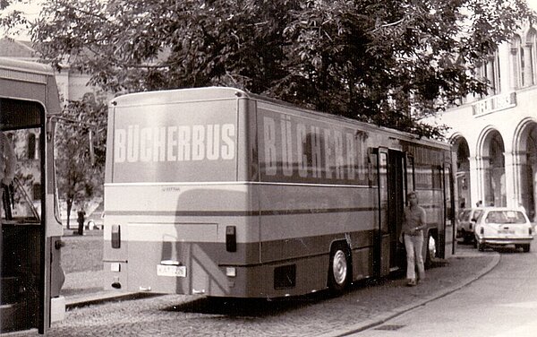 Die dritte Generation, der Bücherbus, von hinten unter einem Baum parkend