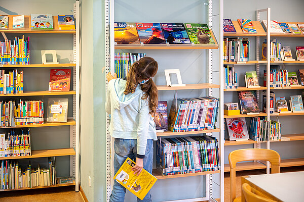Mädchen am Bücherregal