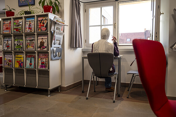 Mädchen mit Kopftuch lernt in der Bibliothek