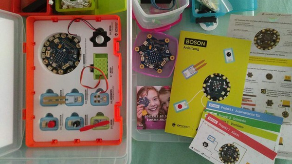 Ein blick von oben in die Calliope mini Box. Man sieht den Mikrocontroller, viele Kabel und restliches Zubehör.