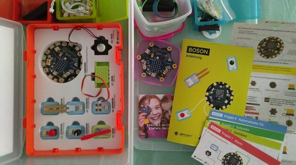 Ein blick von oben in die Calliope mini Box. Man sieht den Mikrocontroller, viele Kabel und restliches Zubehör.